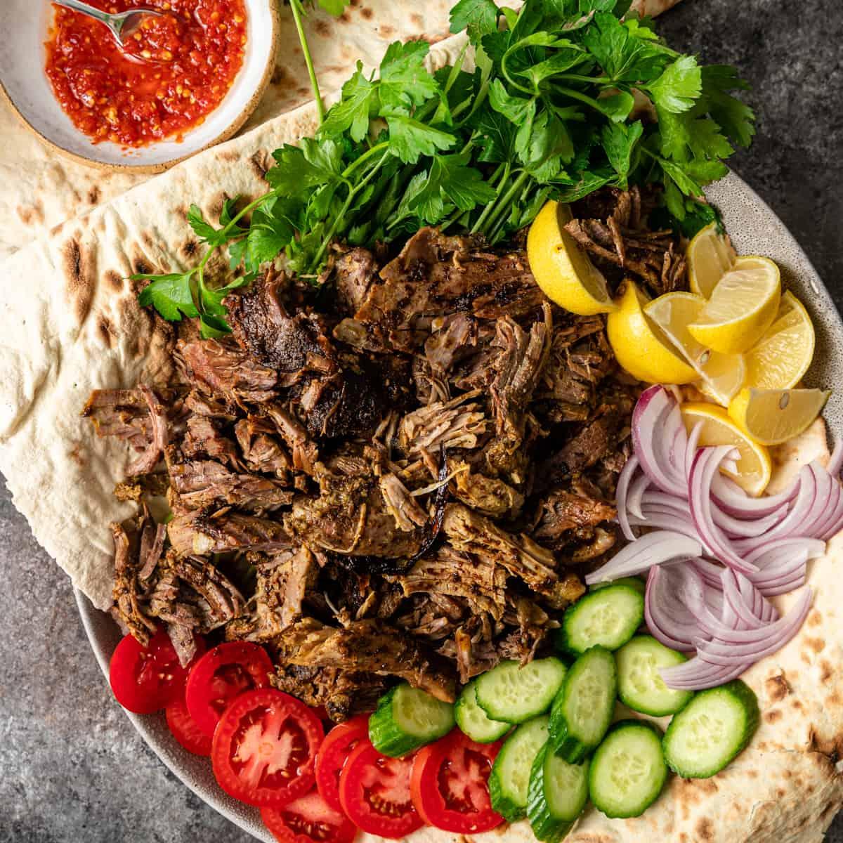 A table laden with delicious Middle Eastern food, with a focus on lamb shawarma