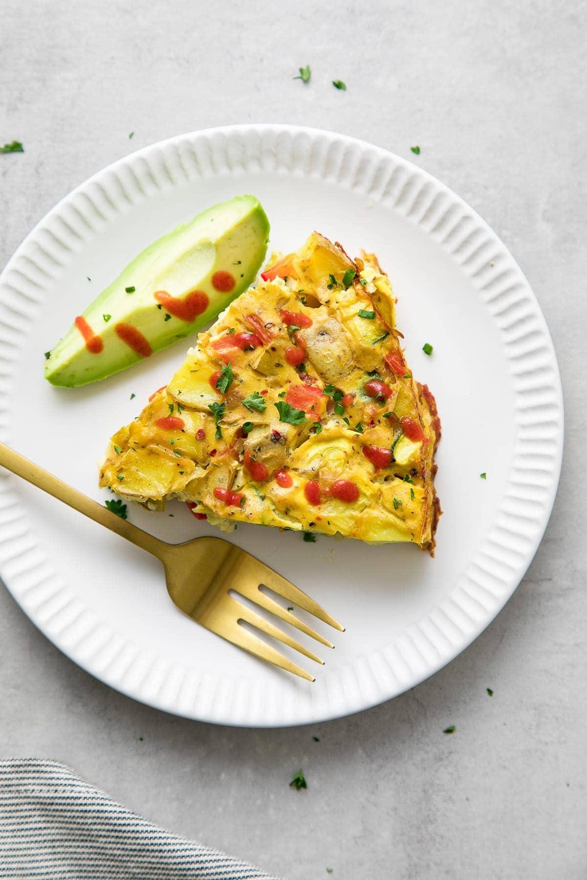 Close-up shot of a slice of vegan frittata, showing the texture and vegetables