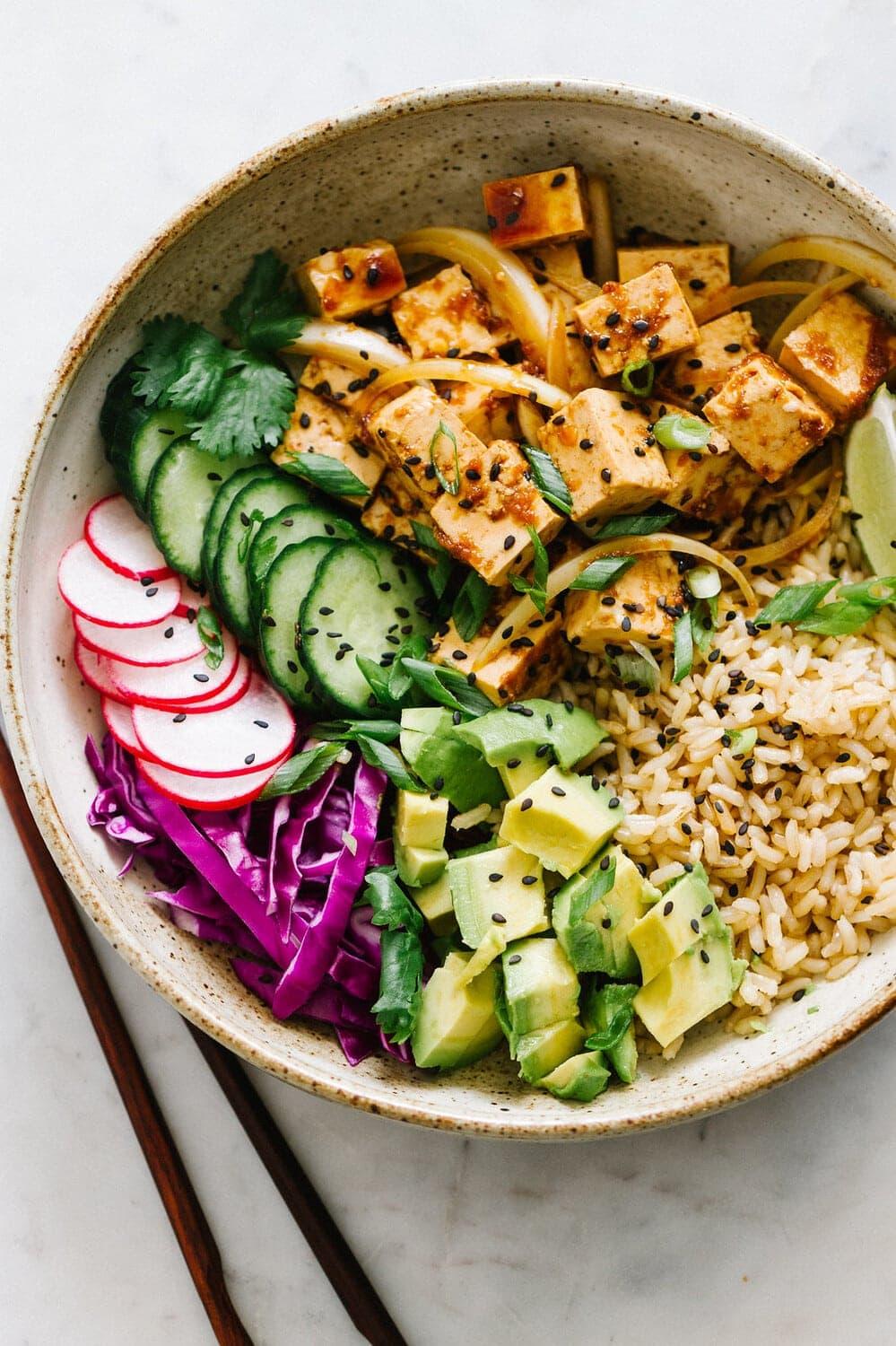 Close-up shot of a perfectly assembled tofu poke rice bowl with a variety of toppings