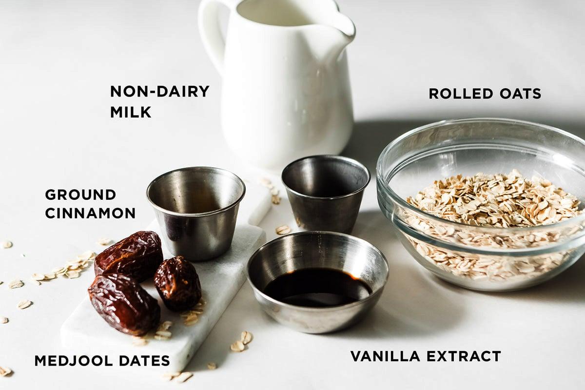 Ingredients for a date and cinnamon smoothie laid out on a wooden countertop.