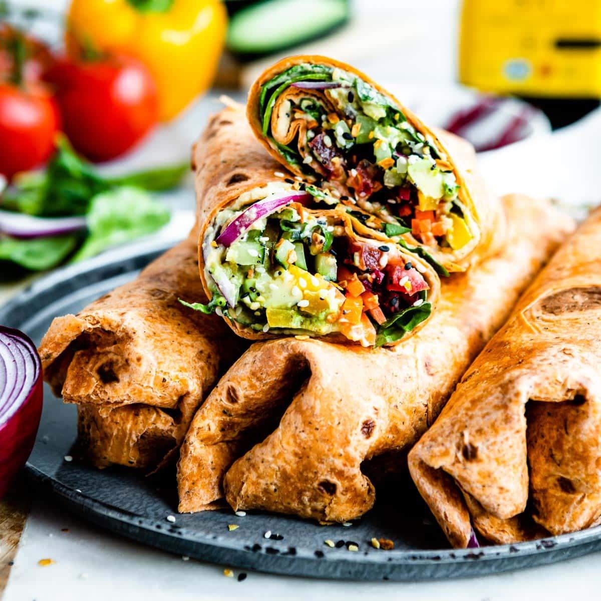 Close up of a leafy greens and hummus wrap with vibrant fillings