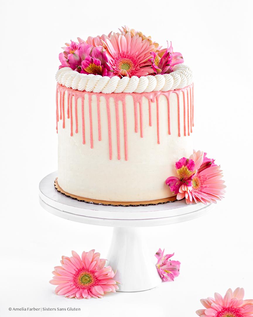 Overhead shot of a whole guava cream cheese birthday cake decorated with fresh guava slices and flowers