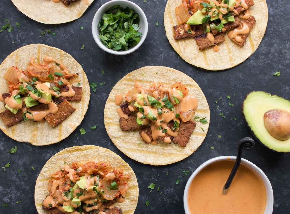 Close-up shot of Kimchi Fusion Tacos with vibrant colors and Gochujang Aioli drizzle