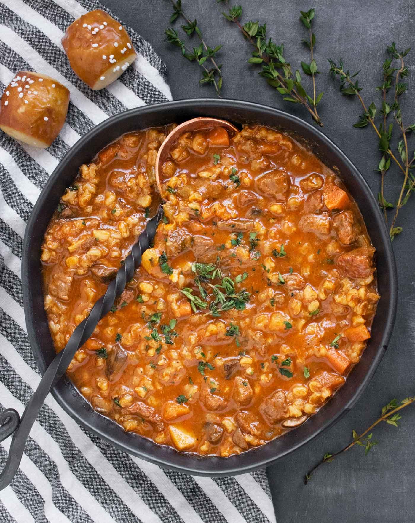 close up of beef and barley soup casserole being baked in an oven