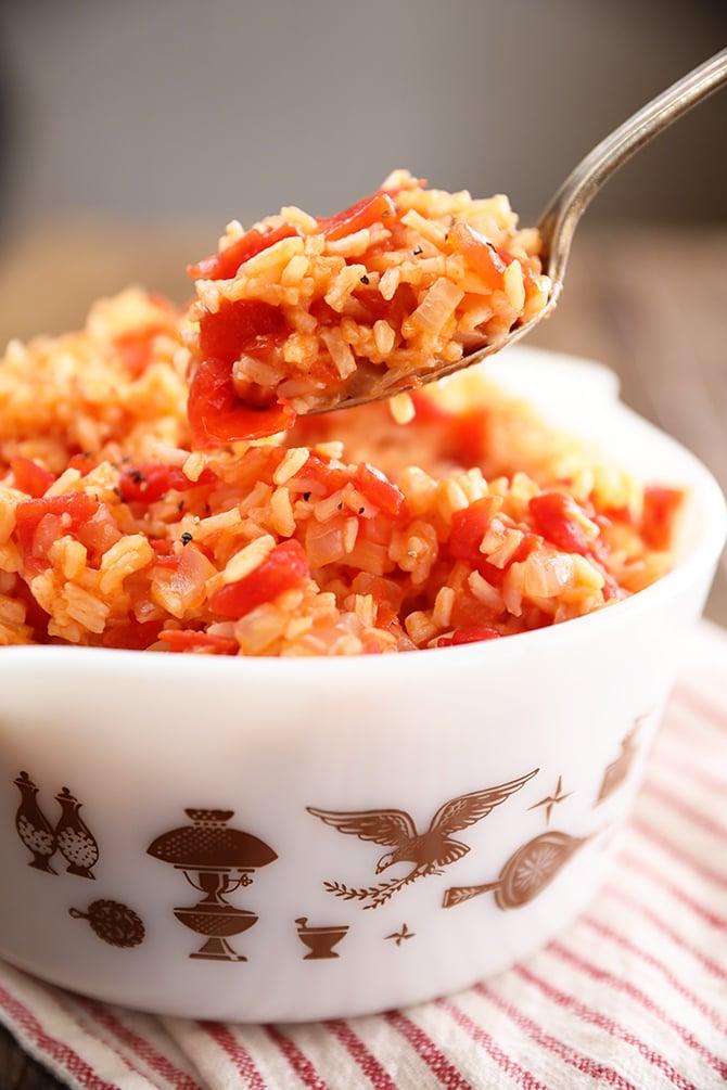 Person enjoying a bowl of steamed rice with tomato salsa