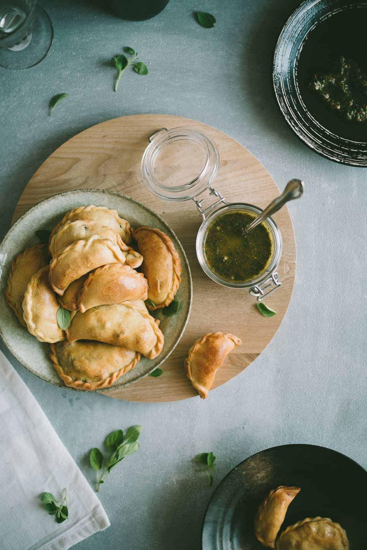 Close-up shot of a single Easter lamb empanada with chimichurri sauce drizzled on top