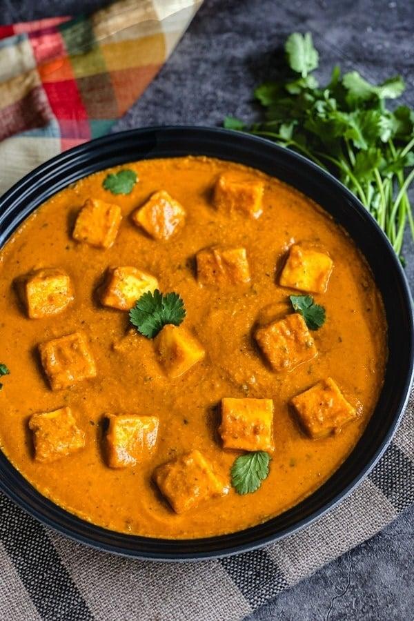 Close-up shot of delicious Paneer Tikka with Creamy Coconut Sauce, garnished with cilantro