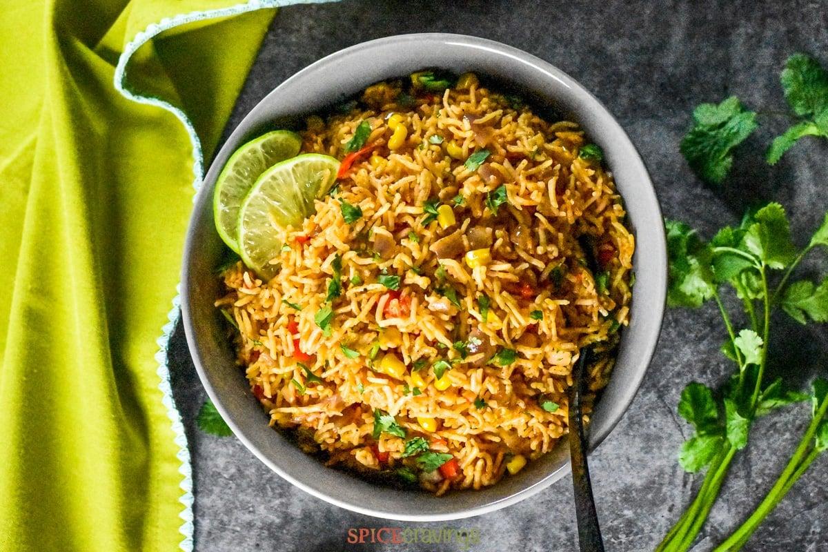 A close-up shot of the finished Instant Pot Mexican Rice with Corn, garnished with cilantro and lime