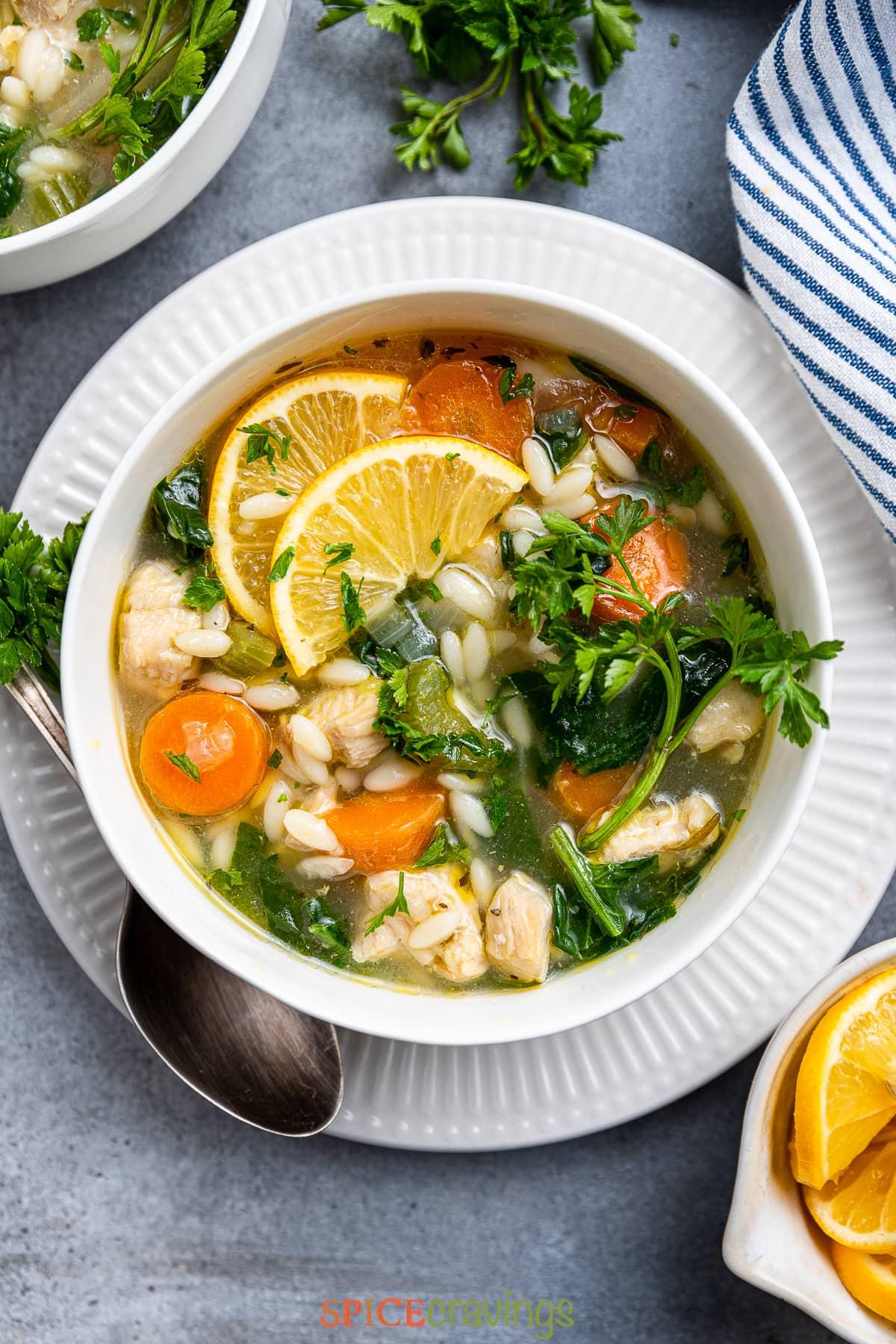 overhead shot of lemon orzo chicken soup in bowls, garnished with fresh parsley