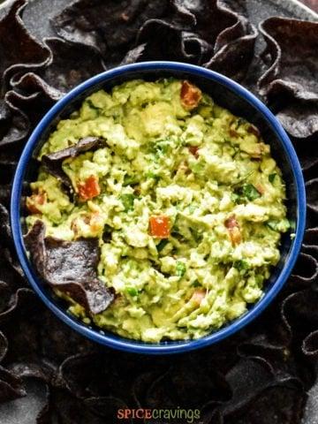 close up of someone stirring fresh guacamole in a bowl, preparing for the rice bowl