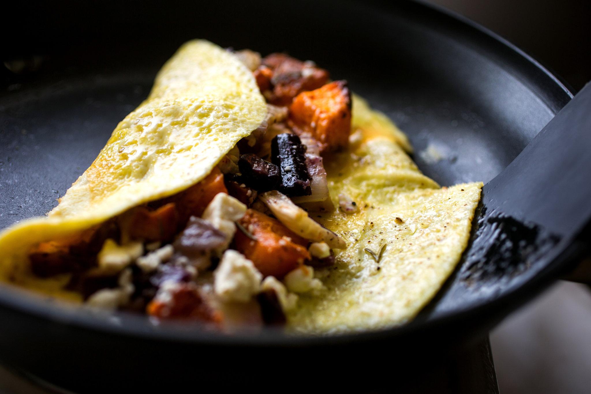 A person preparing the Roasted Vegetable and Cheese Omelet
