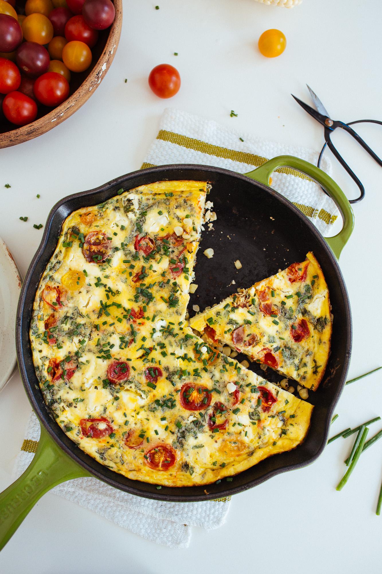 close-up of a slice of farmers market frittata with herbs and vegetables, showcasing the texture