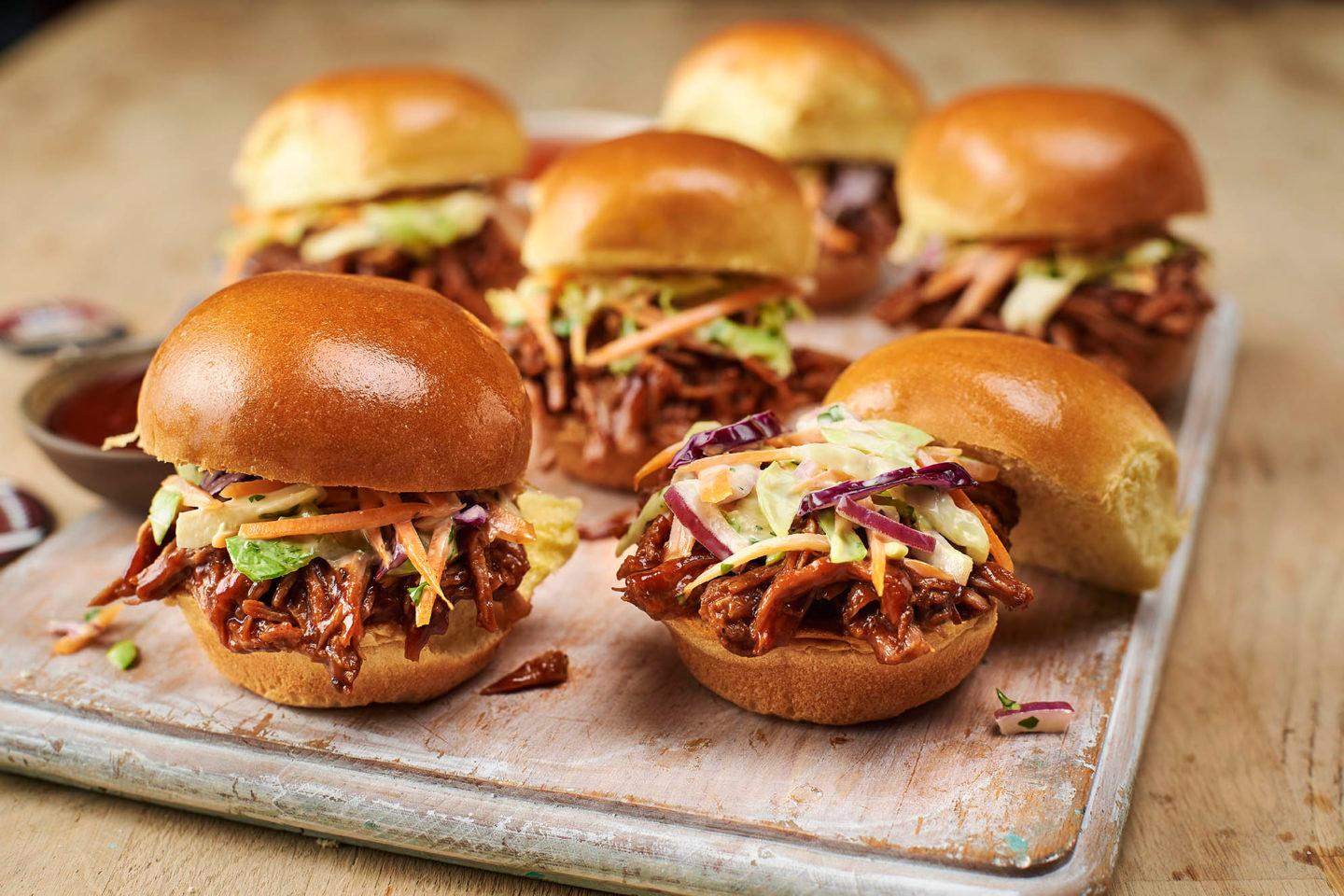 Close-up shot of delicious pulled pork victory sliders on mini brioche buns, garnished with coleslaw