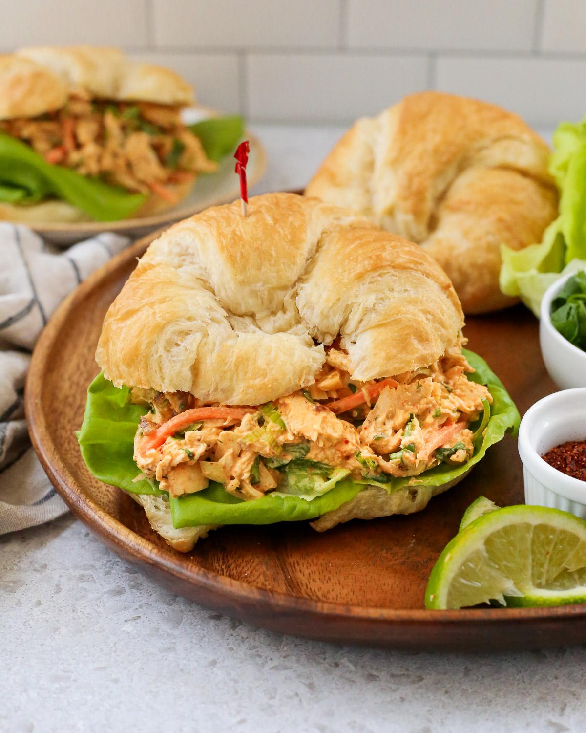 A person taking a bite of a Curried Chicken Salad Sandwich