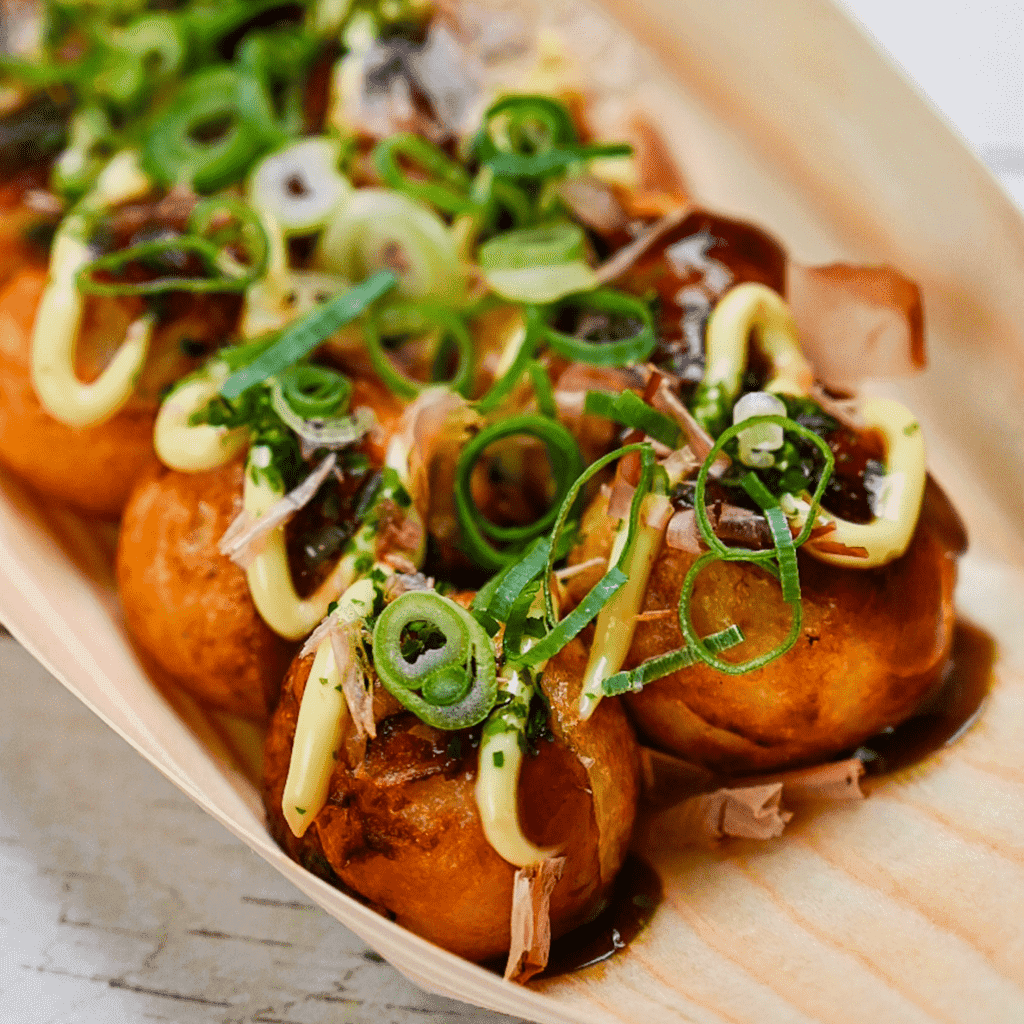 An image of the finished Mushroom Medley Takoyaki served with takoyaki sauce, mayonnaise, dried bonito flakes, and aonori.
