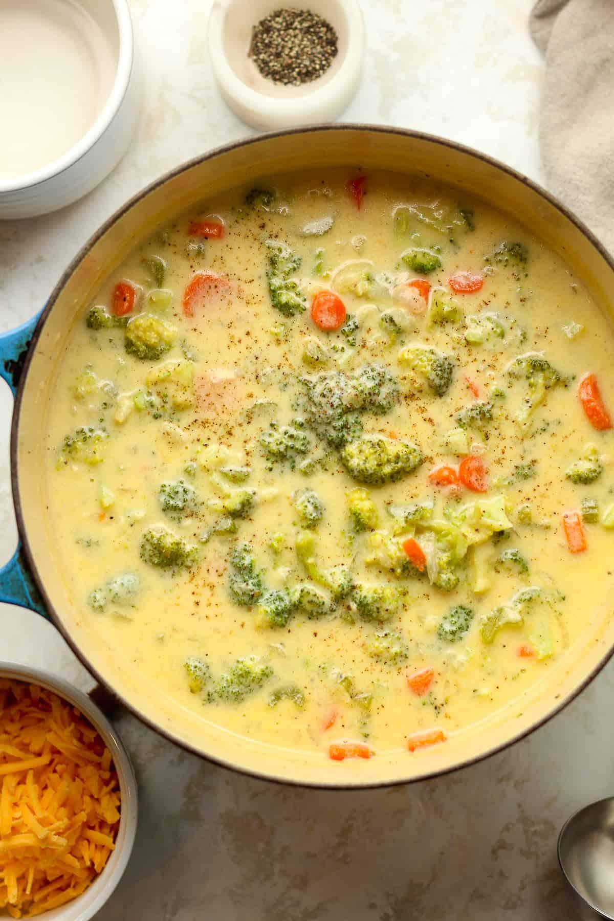 A person enjoying a bowl of creamy broccoli cheddar soup