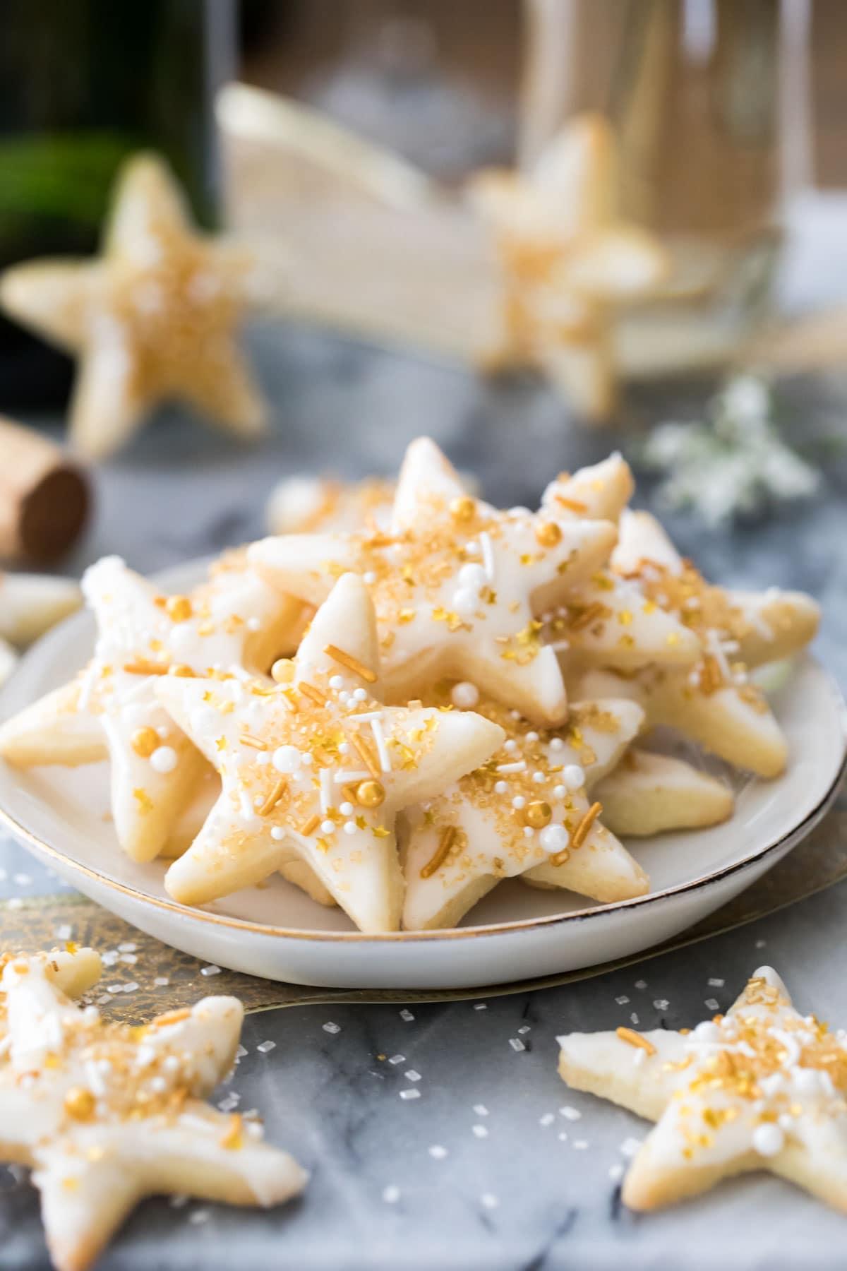 A platter of champagne-infused shortbread cookies in various shapes, decorated with different toppings.