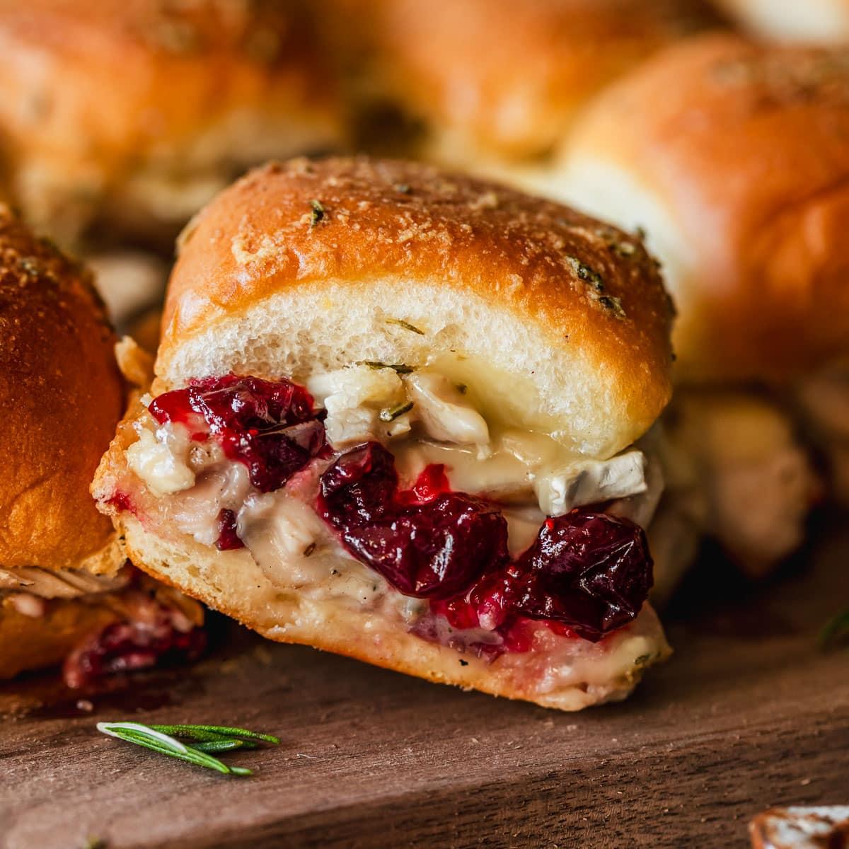 close-up shot of a tailgate turkey slider with cranberry brie and arugula, showing the layers