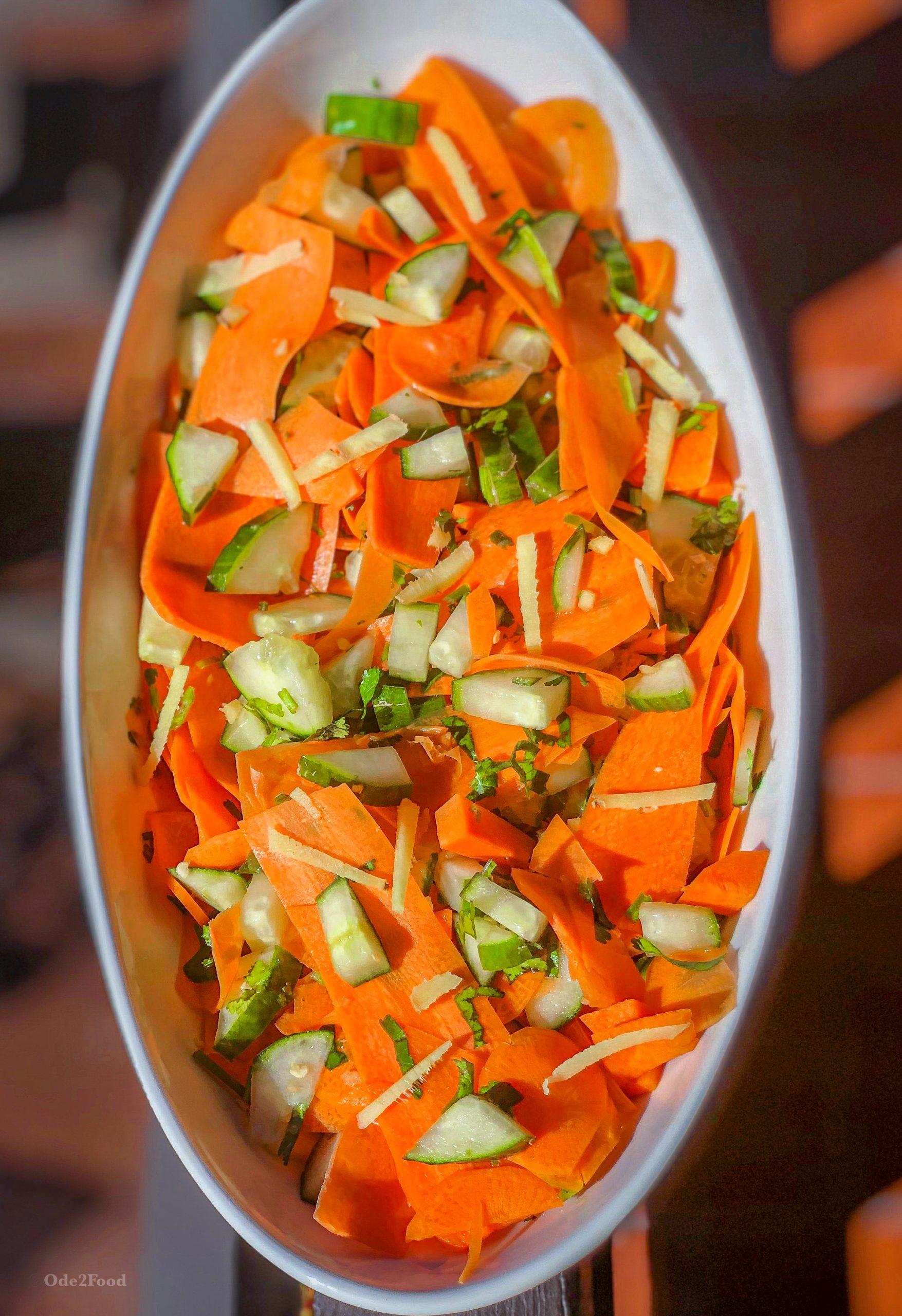 A vibrant bowl of Spicy Carrot & Ginger Fattoush salad with crispy pita chips, showcasing the colorful carrots and herbs.