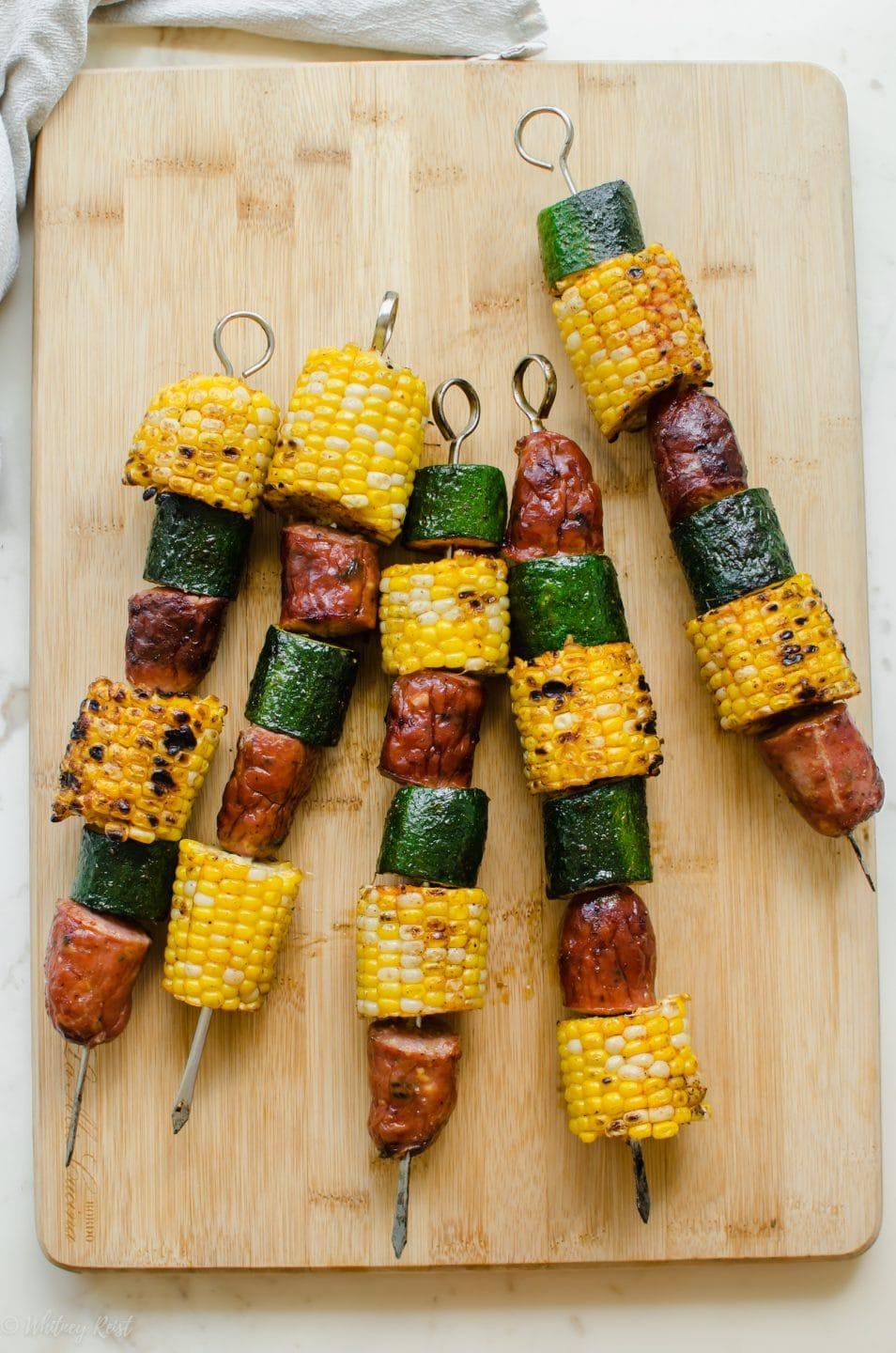 Close up shot of grilled corn and zucchini boats, highlighting the sausage and peppers filling