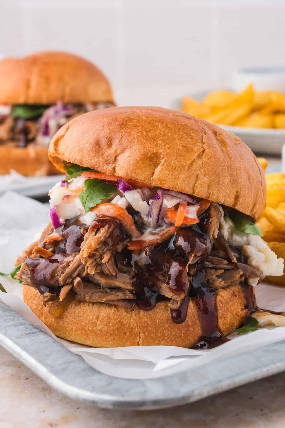 Close-up shot of tender, smoky pulled pork with a side of coleslaw