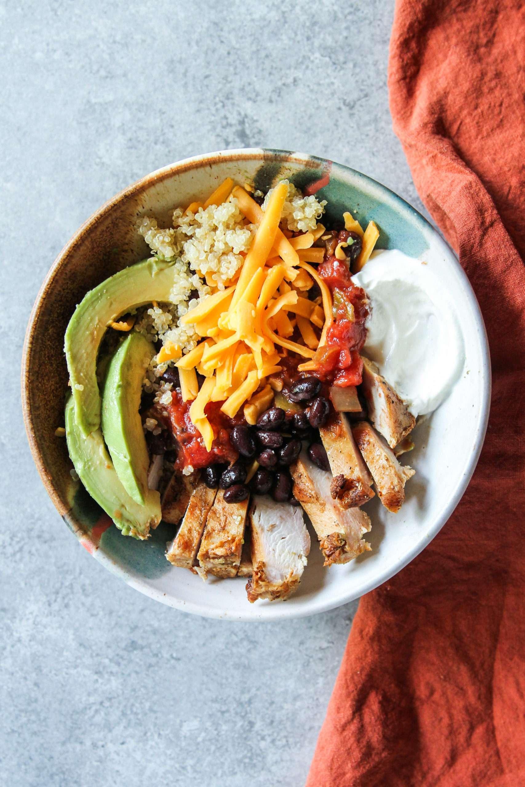 Close-up shot of a vibrant Mexican Fiesta Quinoa Bowl with Chicken and Salsa, focusing on the textures and colors of the ingredients