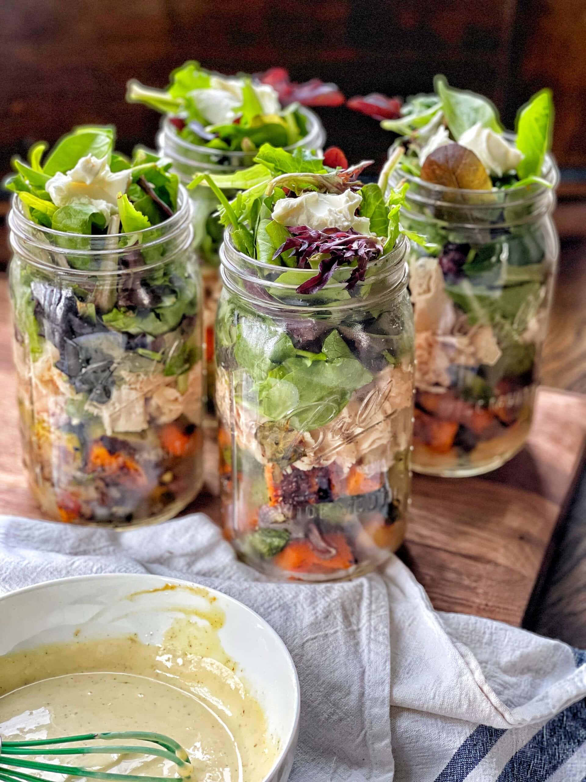 hands packing grilled vegetables into mason jars