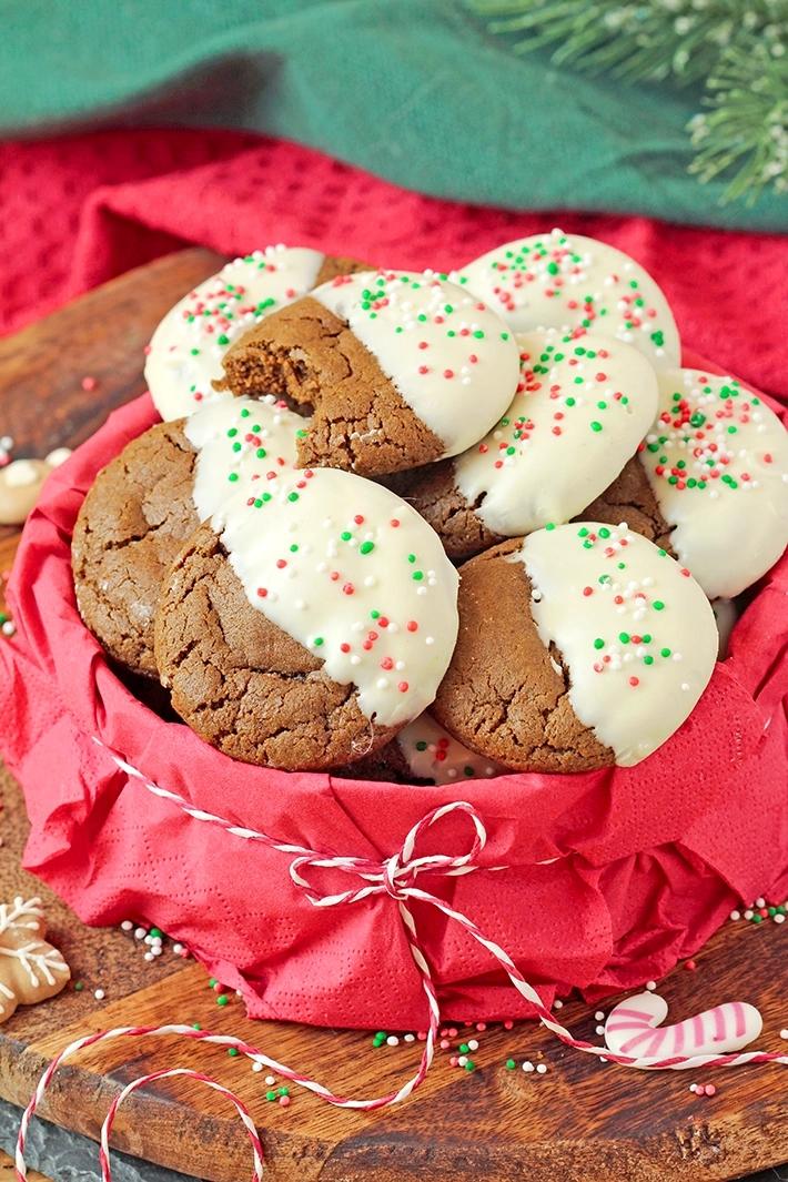 white chocolate dipped gingerbread cookies on a festive platter with holiday decor