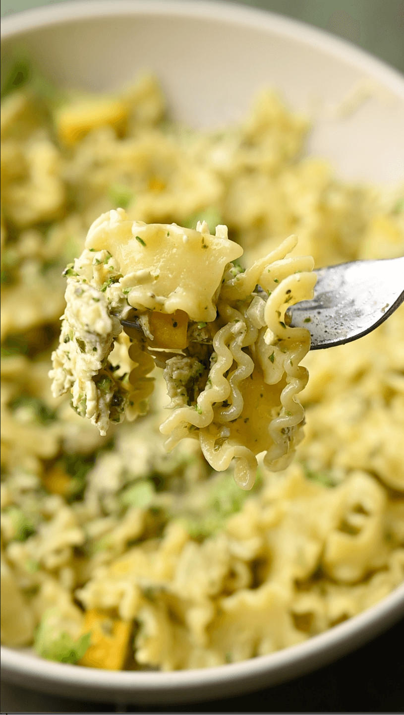 A colorful and appetizing image of gluten-free pasta with creamy pesto and chicken, garnished with fresh basil