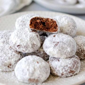 Close-up shot of a plate of Mexican Wedding Cookies dusted with powdered sugar