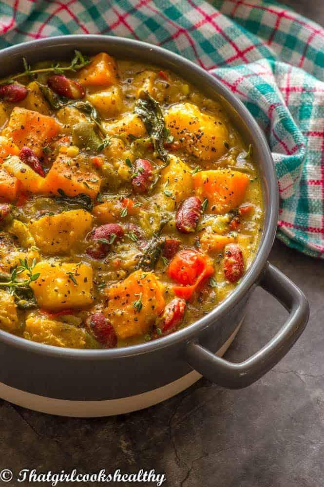 Close-up shot of Caribbean Plantain and Coconut Curry simmering in a pot, showing the vibrant colors and textures.
