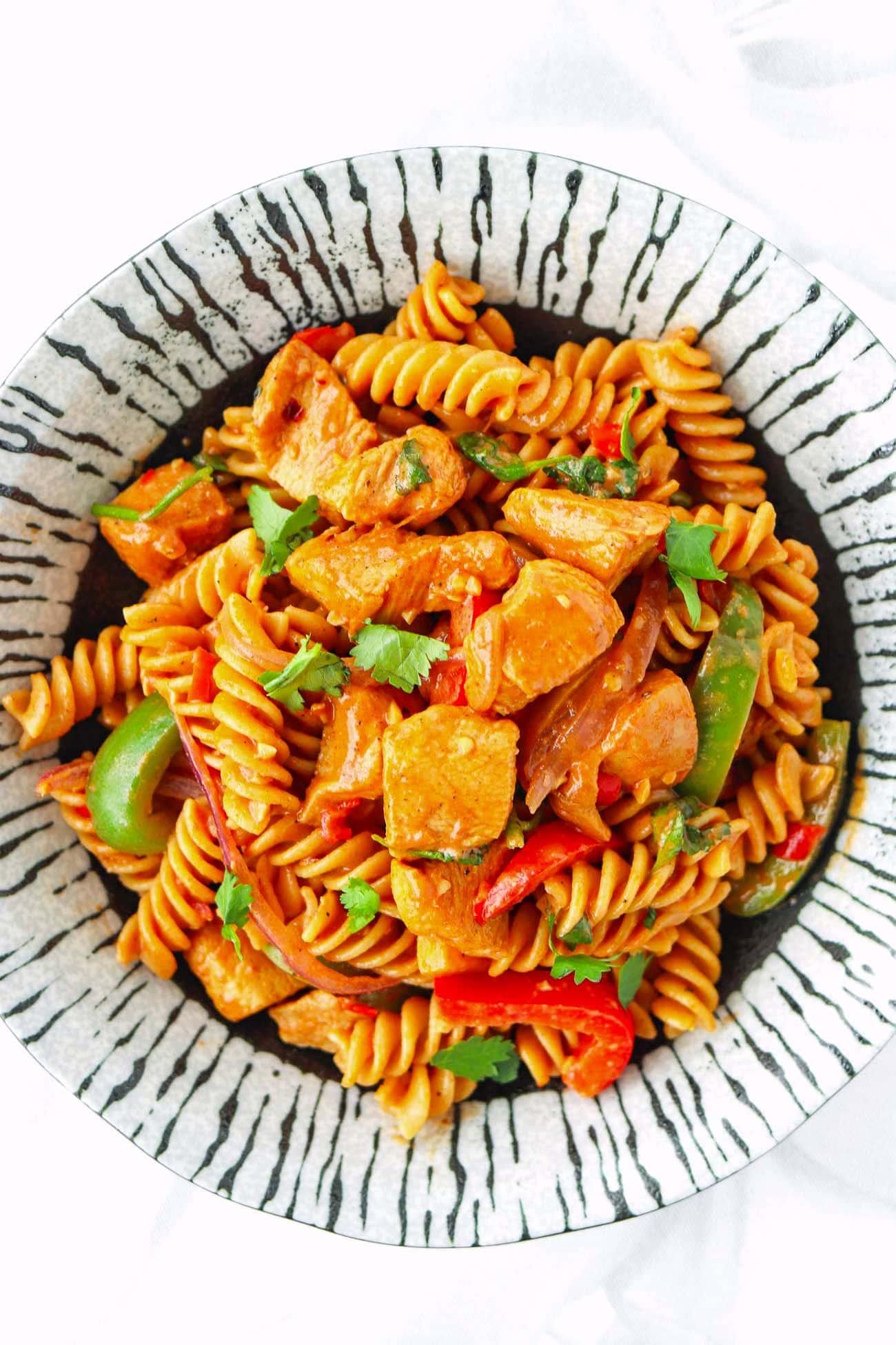close-up shot of creamy chicken fajita pasta in a bowl with cilantro garnish