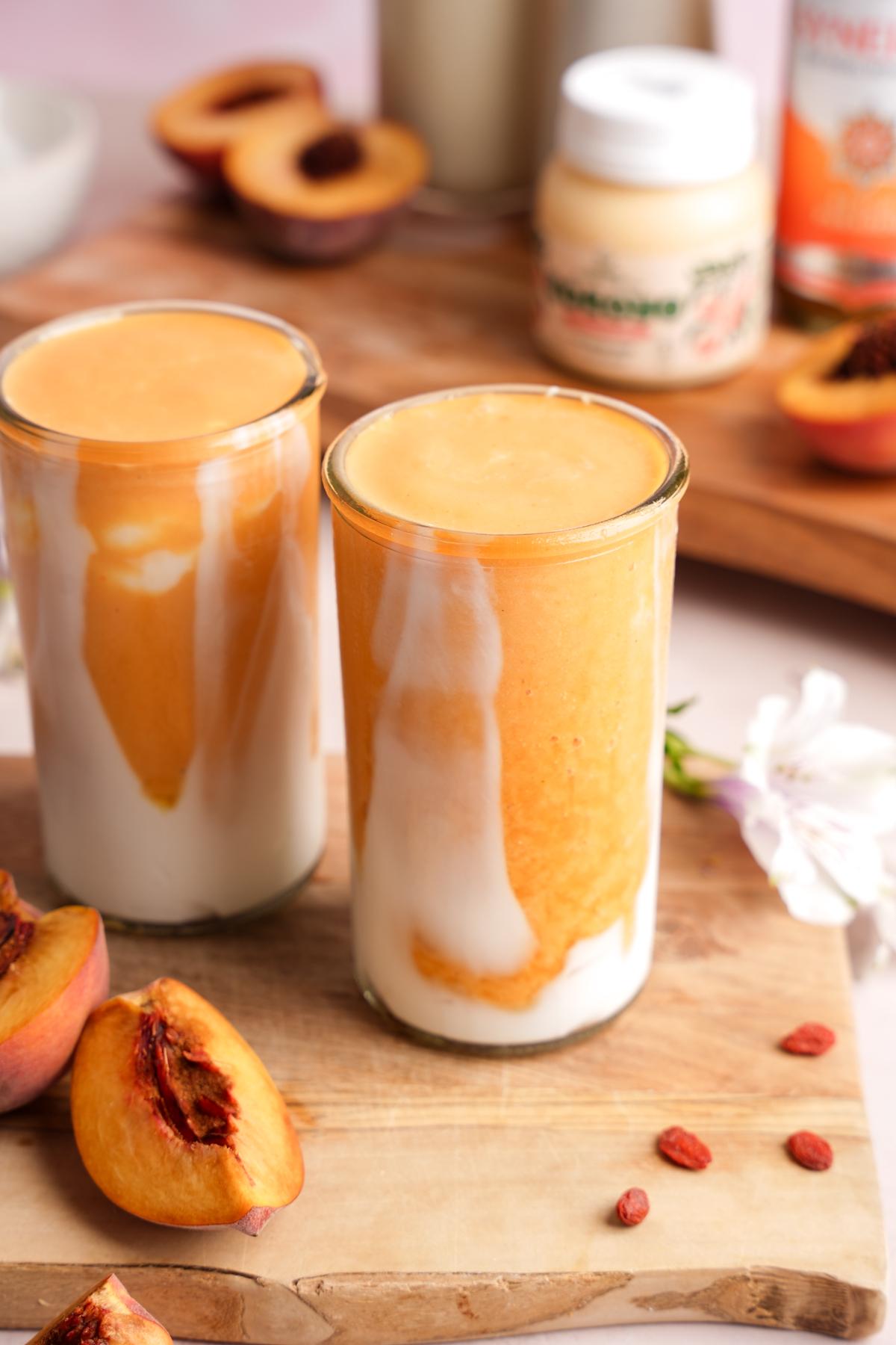 sun-drenched peaches on a rustic wooden table, with a glass of vanilla peach smoothie in the background