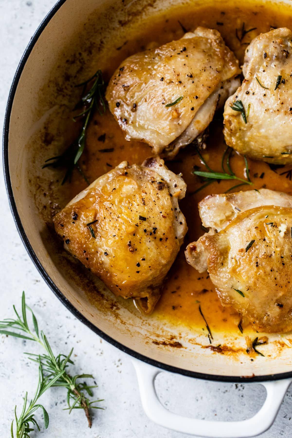 A close up of a piece of grilled chicken with a pat of rosemary and sage butter melting on top