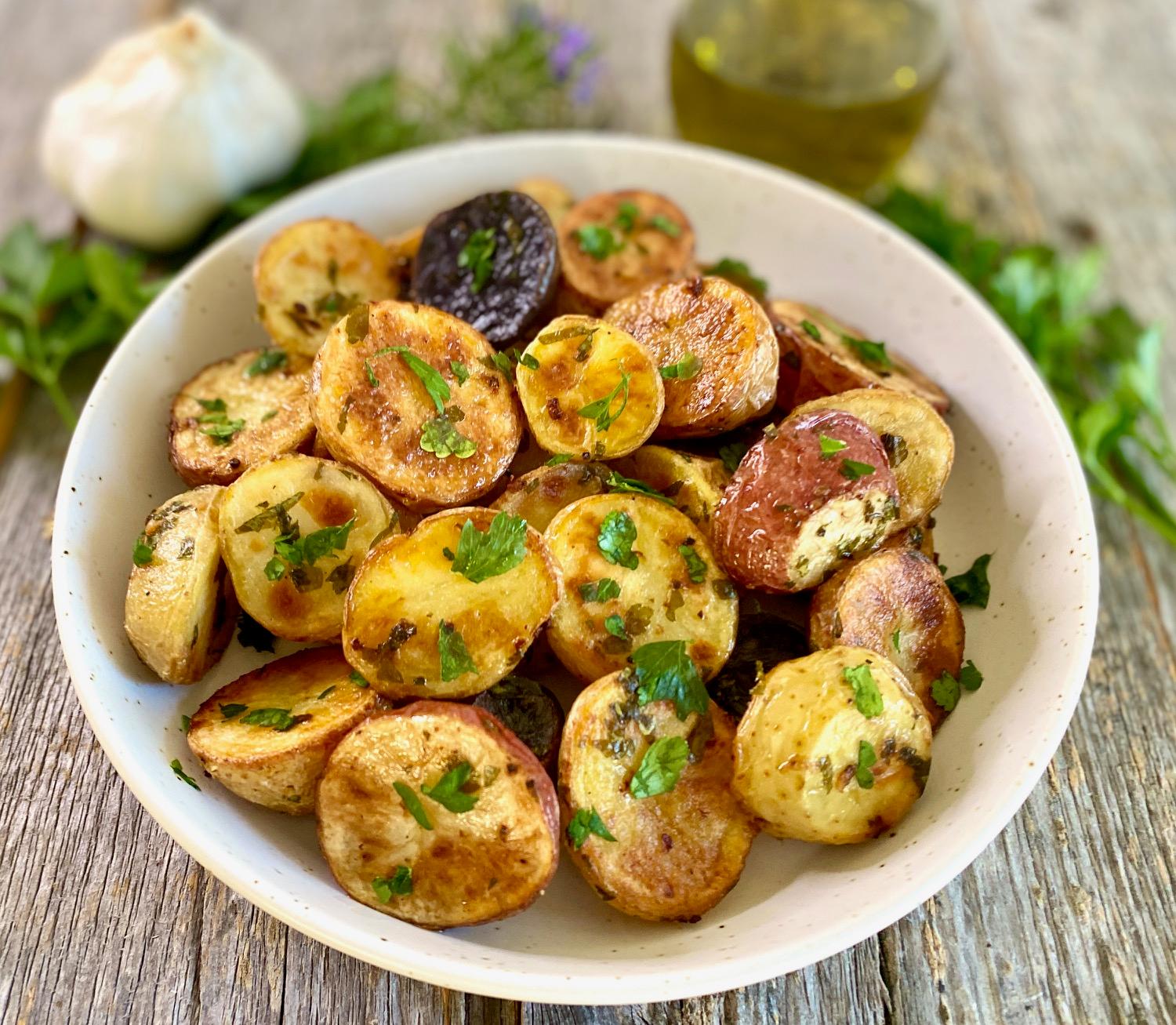 A sheet pan overflowing with perfectly roasted, golden potatoes, seasoned with herbs and spices