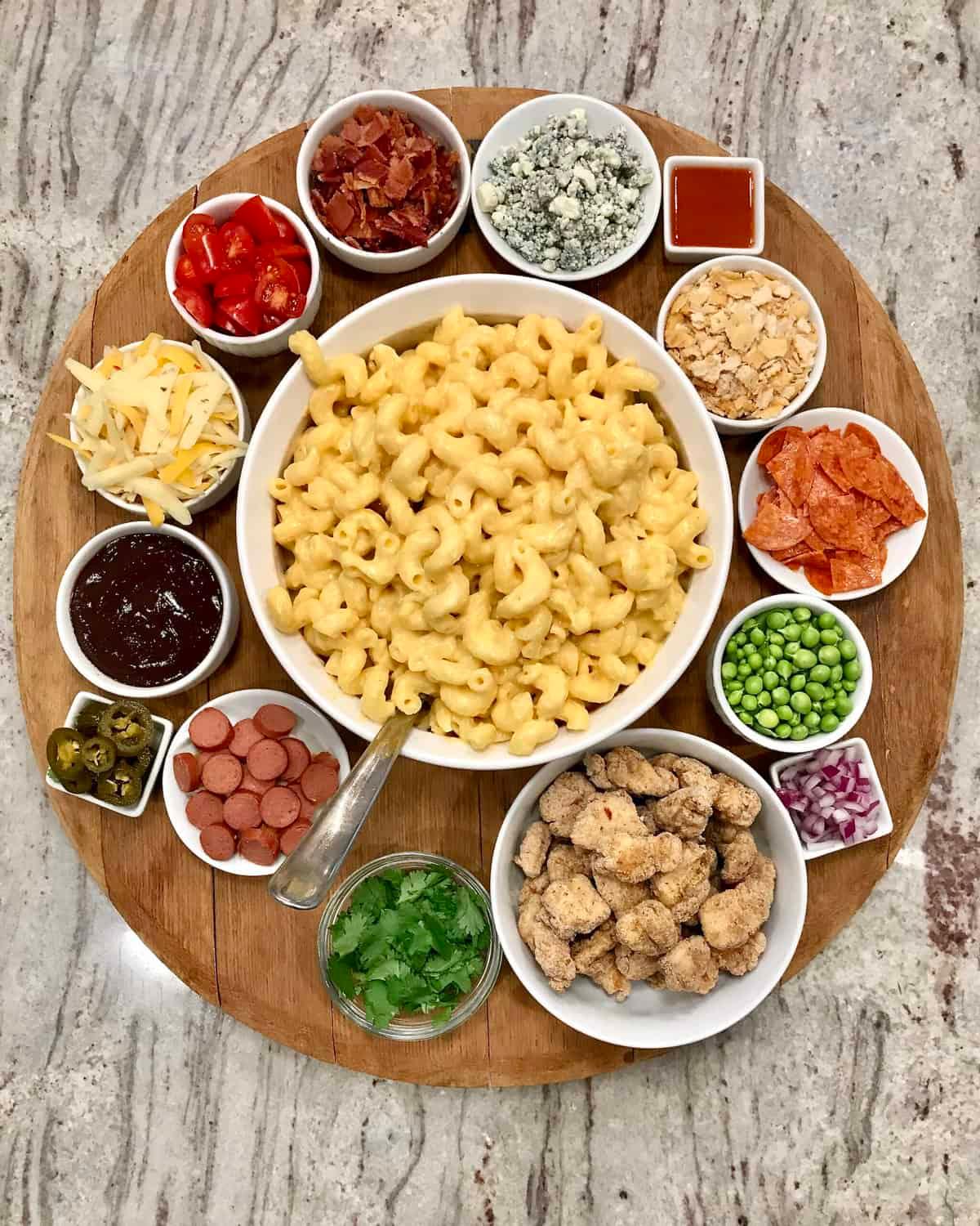 A table set with a serving dish of mac and cheese and other food items