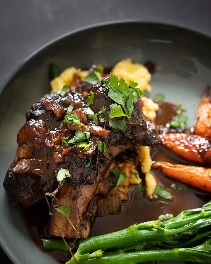 Close-up of a single, perfectly tender beef short rib glistening with red wine sauce