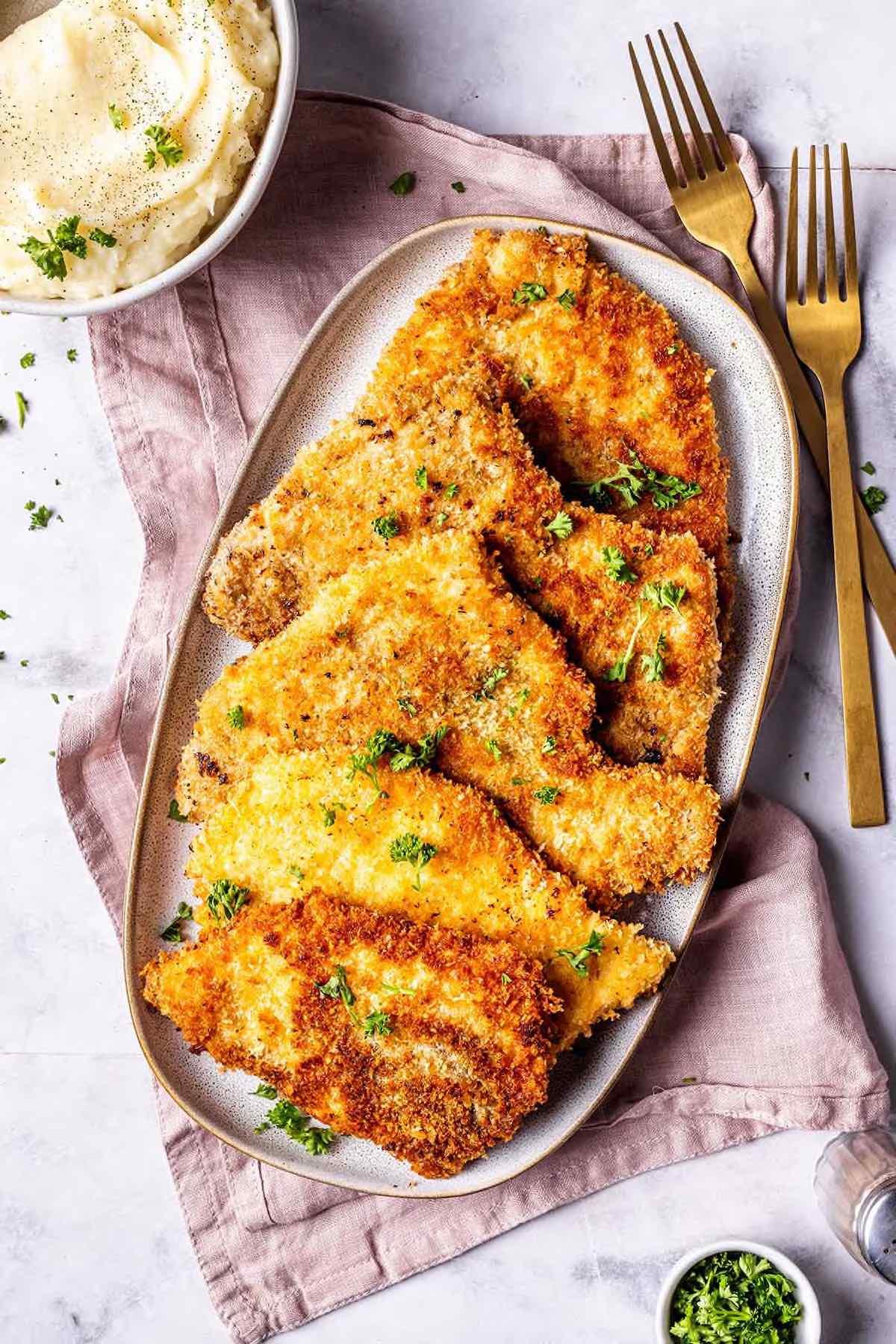 skillet turkey cutlets with golden crust close up, served with side dish