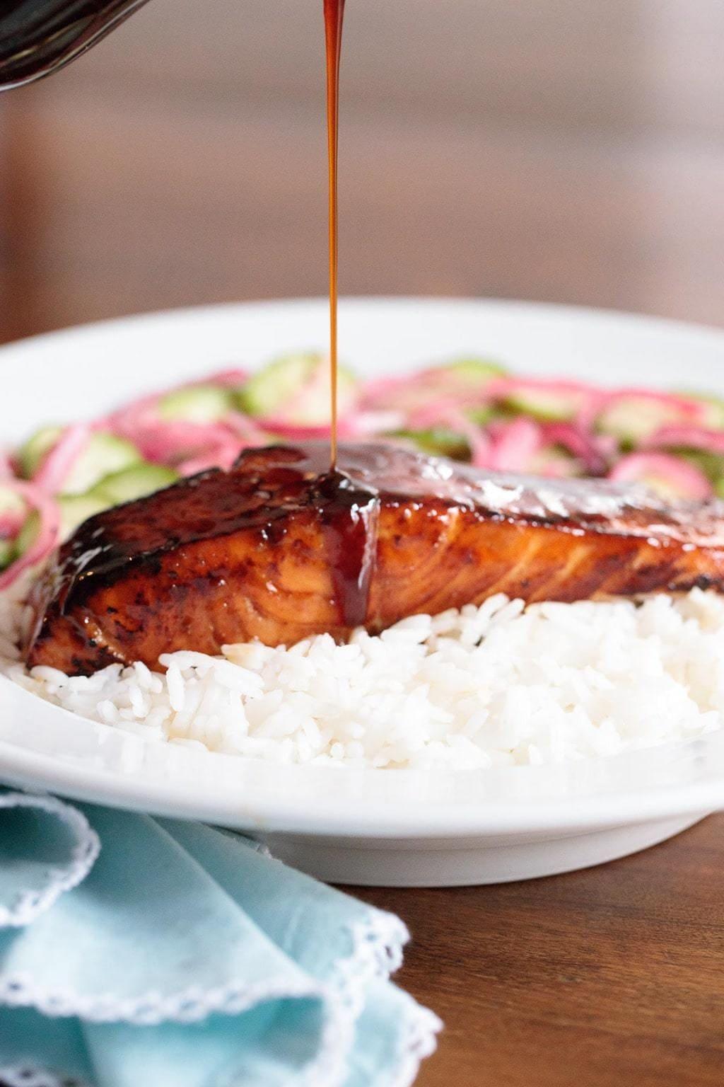 raw salmon fillets being glazed with honey-cilantro sauce