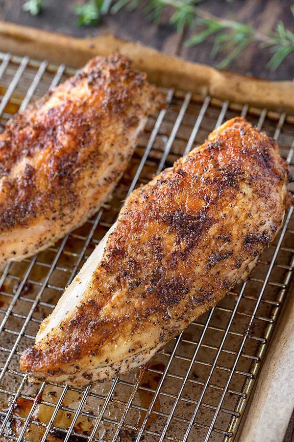 Chicken breasts being placed into a roasting pan