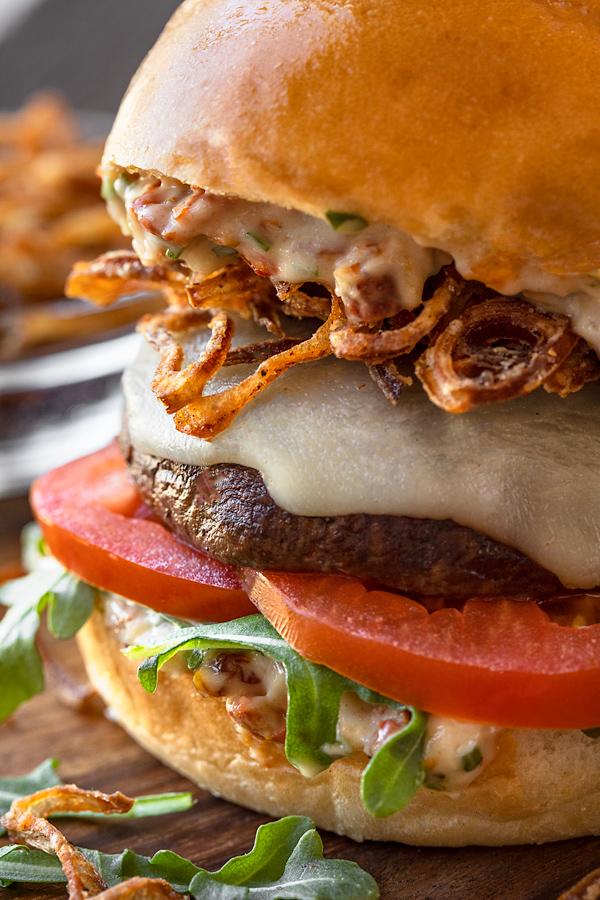Close-up shot of a portobello mushroom burger with vibrant toppings