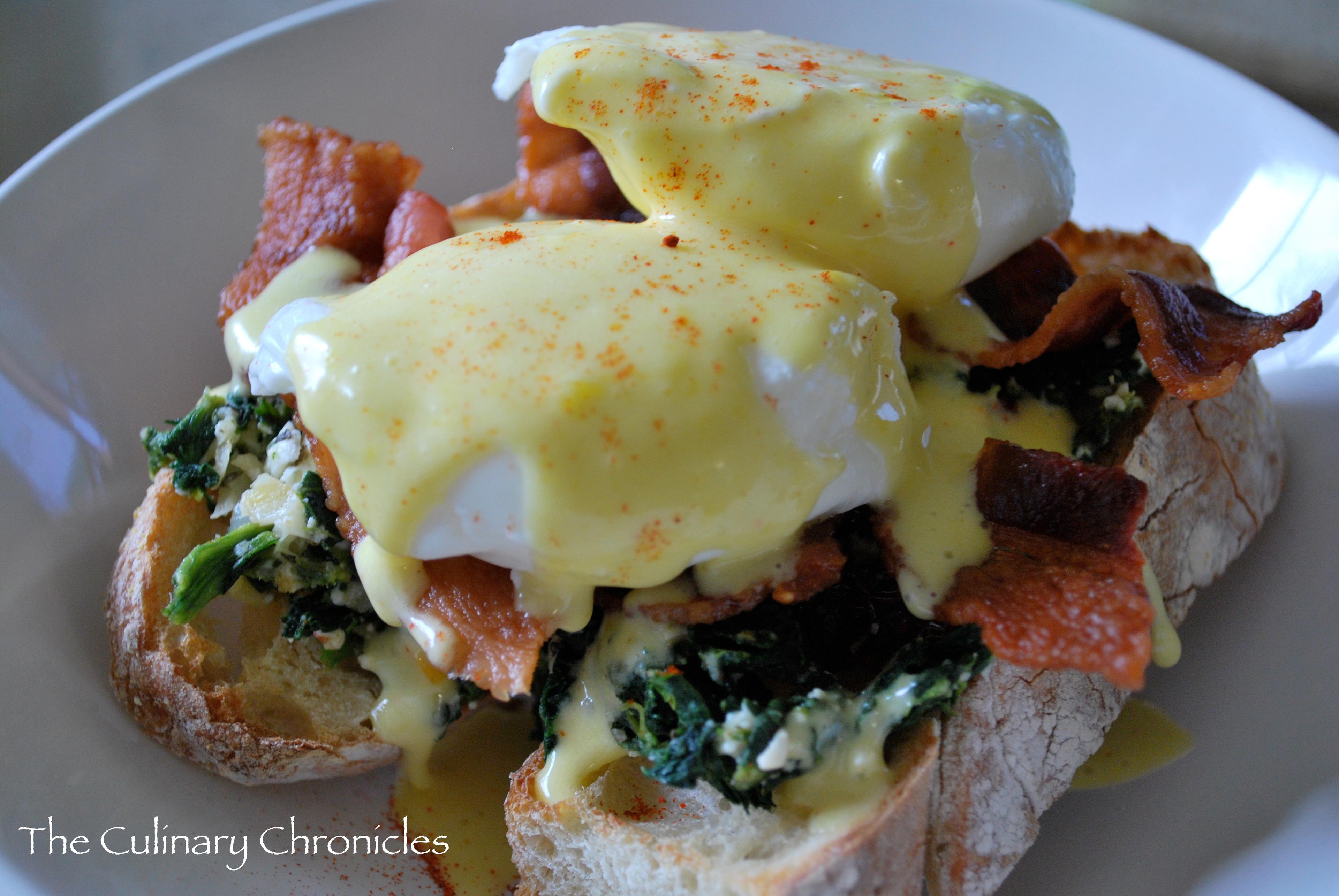 A mouthwatering close-up shot of Mediterranean Benedict with Feta, showcasing the creamy eggs, crumbly feta, and vibrant spinach.