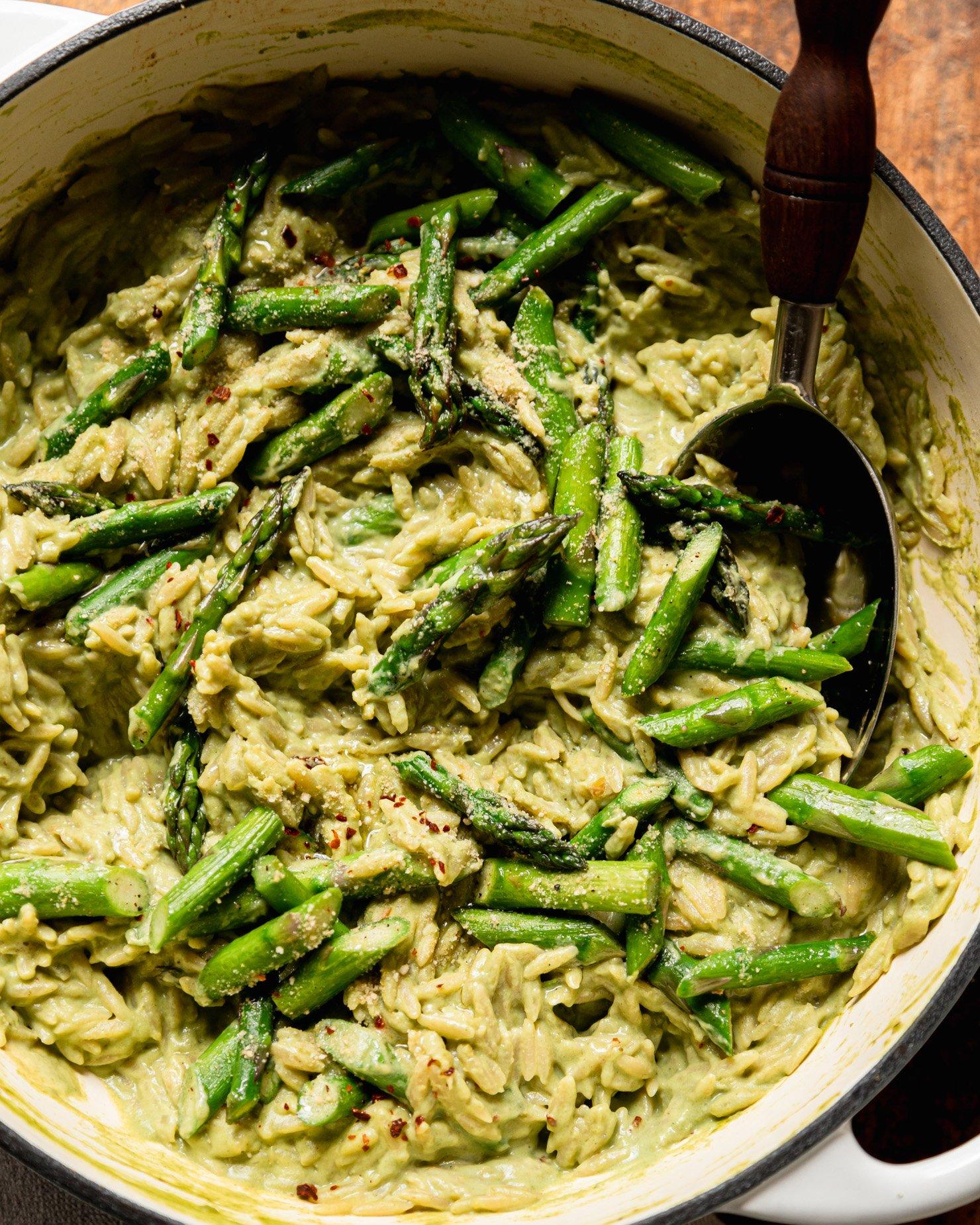 close up shot of spring asparagus and green bean risotto being stirred in a pot