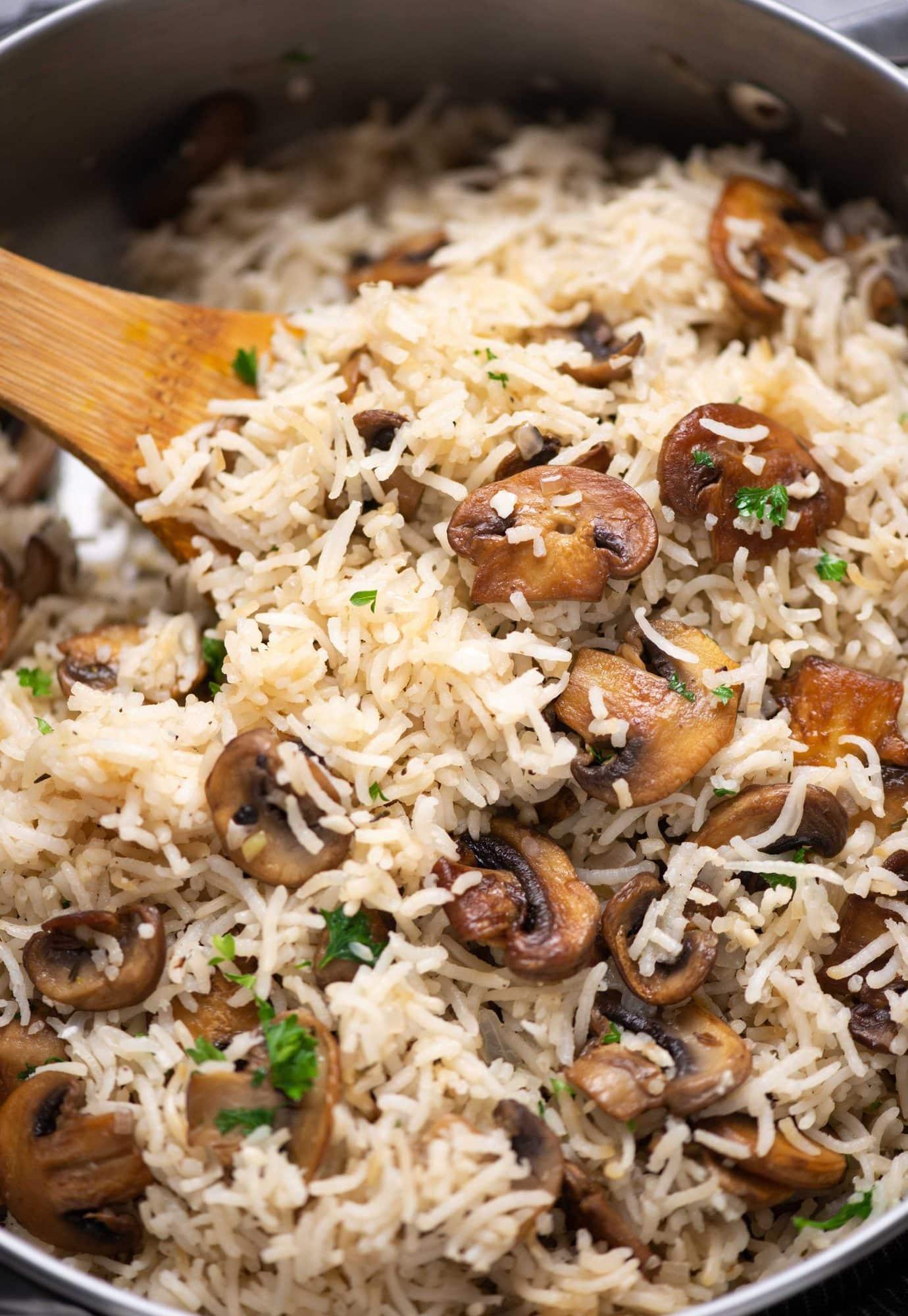 A close-up shot of a bowl of boiled rice with mushrooms and thyme
