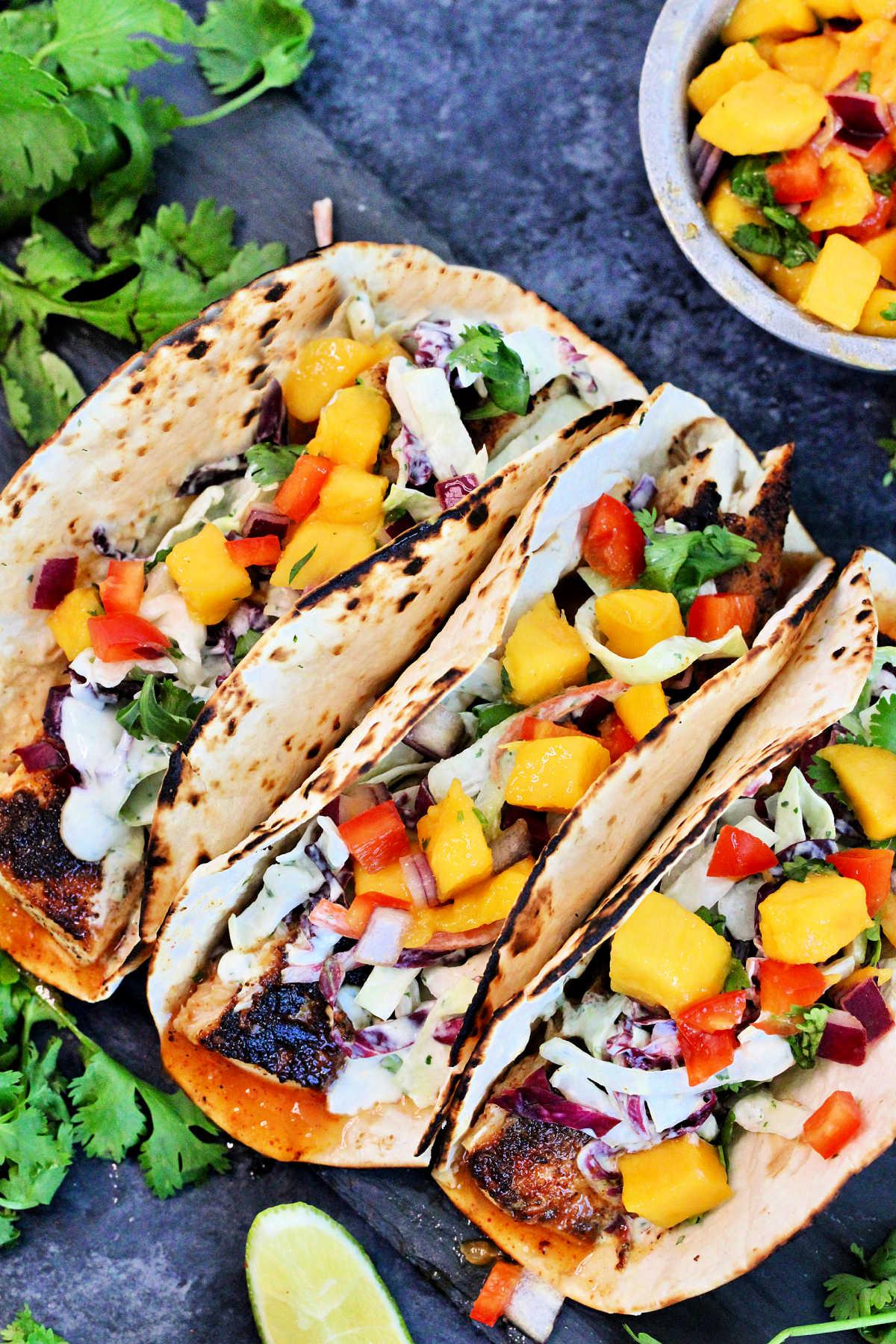 People enjoying mahi mahi tacos around a table