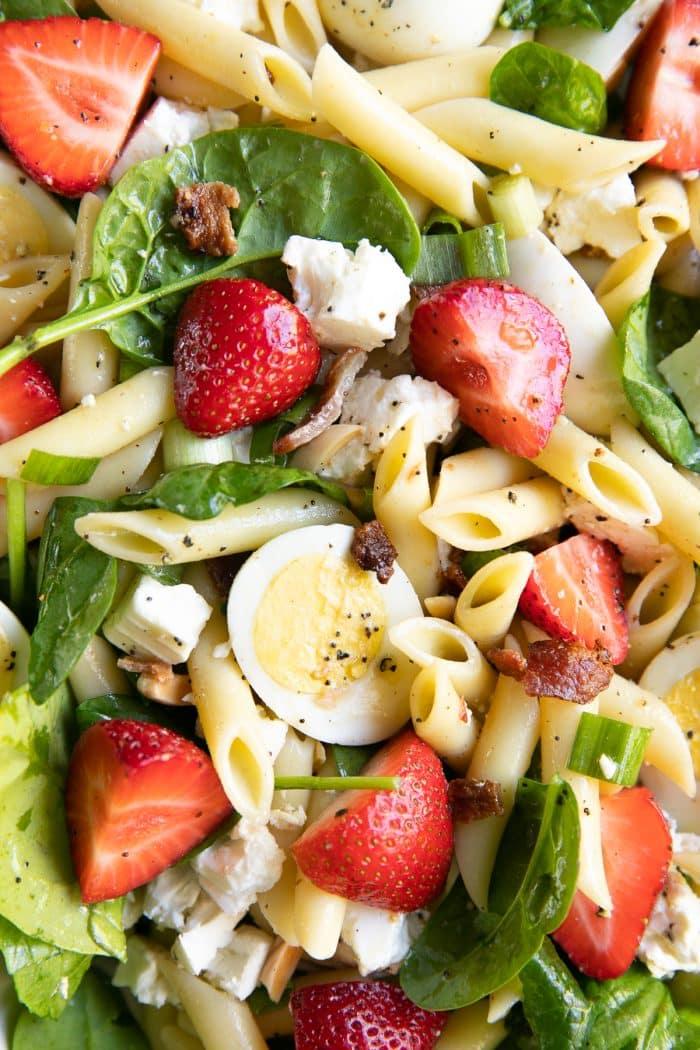 close up shot of strawberry spinach pasta salad in a bowl