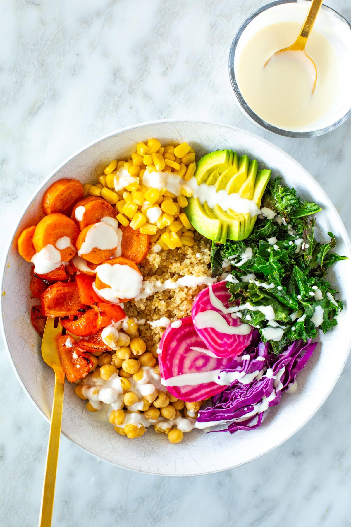 Person enjoying a Rainbow Veggie & Quinoa Rice Bowl in a cozy setting