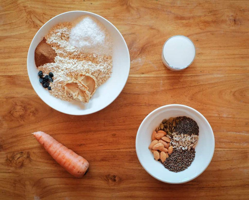 ingredients for carrot cake oatmeal arranged on a wooden surface