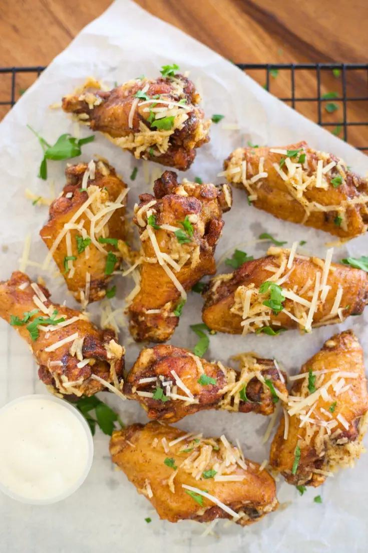 Close up of crispy garlic parmesan wings with fresh parsley garnish