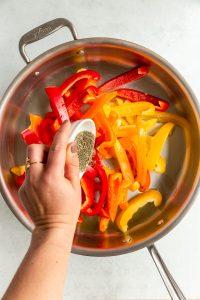 Close up of a person frying sweet peppers in a pan